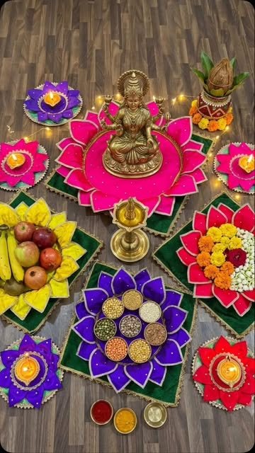 Fabric lotus mats arranged around a Lakshmi idol with diyas