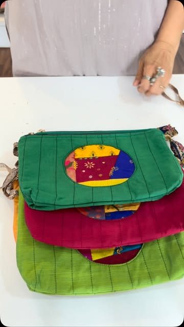 Hands holding a stack of handmade zip pouches